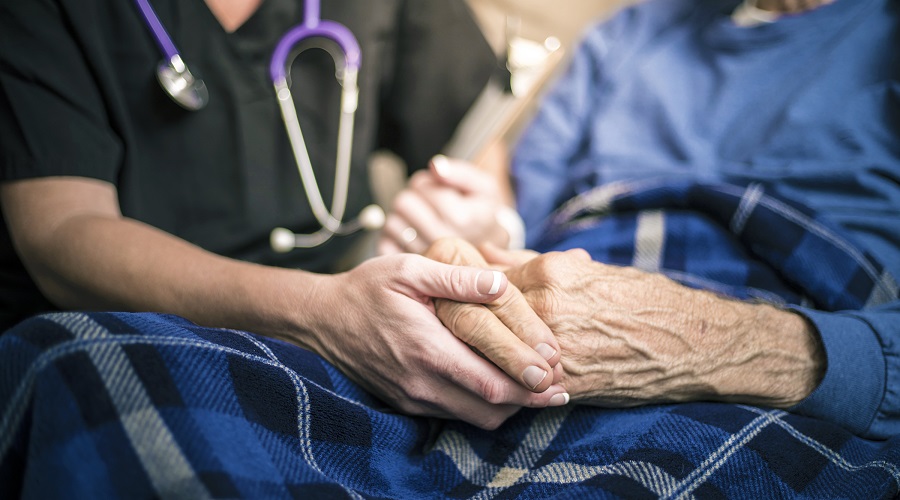 closeup nurse holding elderly patients hands