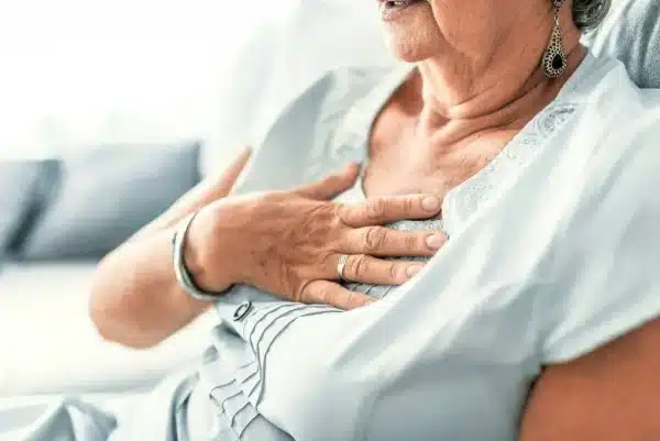 a caucasian or perhaps latina woman with her hand on her chest as if shes suffering with pain heart attack heartburn acid reflux gerd original e1677786158429