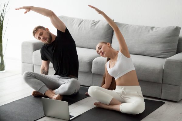 couple doing yoga poses at home e1679153435285