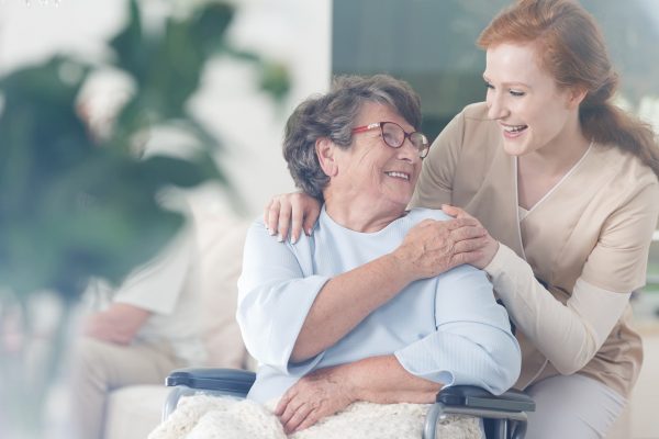 happy patient is holding caregiver for a hand while spending time together e1679605387524