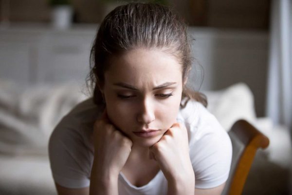 young sad woman resting her head on her hands 1920x1280 1 e1666875148774