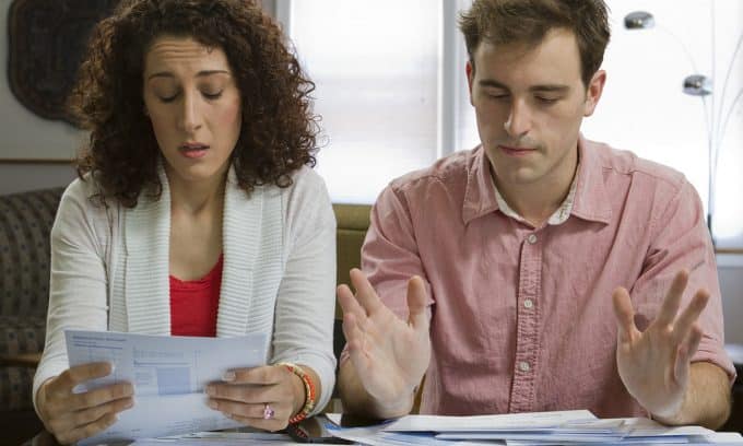 young couple reviewing personal financials concerned e1675594085602